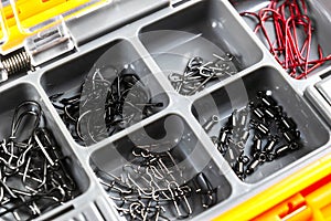 Opened tackle box with fishing hooks and accessories. Fishing hooks in box sections. Case for tackle elements. Fishing accessories photo