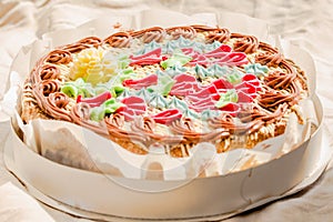 Opened Traditional Kiev Whole round cake with hazelnuts and butter cream top view. Nut cake in packaging, delicious dessert. Close