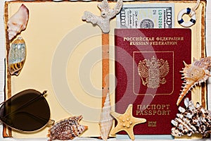 Opened travel book with russian passport and sea shells