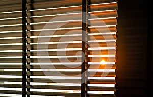 Opened venetian plastic blinds with sunlight in the morning. White plastic window with blinds. Interior design of living room