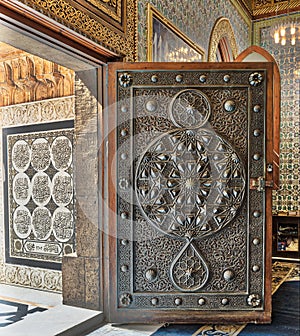Opened wooden aged door with ornate bronzed floral patterns, Mosque of The Manial Palace of Prince Mohammed Ali, Cairo, Egypt