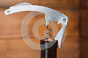 Opening a bottle of red wine metal corkscrew