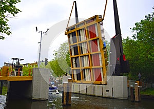 Opening bridge to let boat pass underneath in a narrow Amsterdam channel