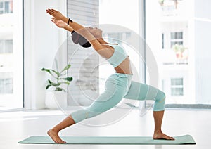 Opening the heart chakra. Full length shot of an attractive young woman practising yoga in the studio and holding a high