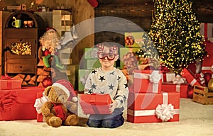 Opening his Christmas present. merry christmas. happy child party glasses. son ready to celebrate winter holidays. small