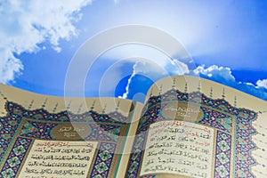 Opening pages of holy book Qur`an with cloud