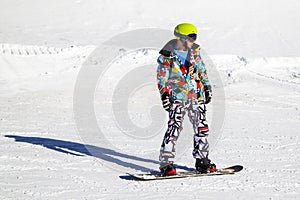 Opening of a ski resort, a young man on a snowboard on a background of mountains. Russia, Sochi