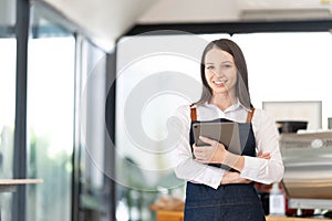 Opening a small business, AHappy Asian woman in an apron standing near a bar counter coffee shop, Small business owner