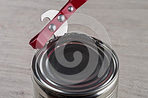 Opening a tin can with a can opener