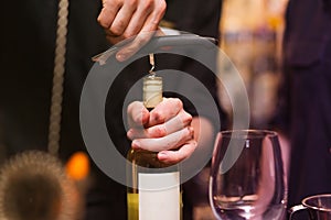 Opening a wine bottle with corkscrew