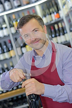 Opening wine bottle with corkscrew in bar