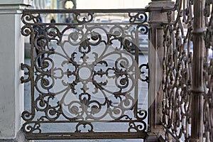An openwork cast iron lattice adorns the porch of the house