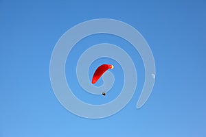 The operated  parachute flies in the blue sky