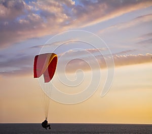 The operated parachute flies low above the sea