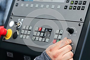 Operating the controls of CNC machine