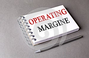 OPERATING MARGINE word on notebook on grey background