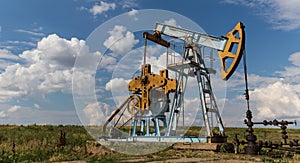 Operating oil and gas well profiled on cloudy sky