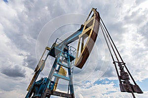 Operating oil and gas well profiled on cloudy sky