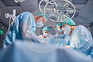 Operating room caucasian team of professional surgeons and nurses working together