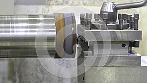 The operation of lathe machine cutting the metal shaft parts. The metalworking process by turning machine.