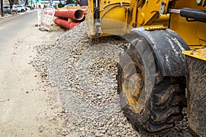 Operation of Wheel loader excavator for unloading crushed stone during the repair of city utilities and road works. Housing and