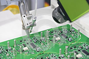 The operation of wiring the motherboard by robotic soldering machine. The industry 4.0 in electronics parts manufacturing process