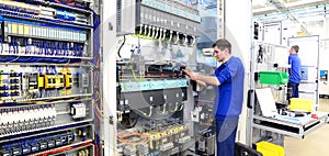 Operator assembles machine in a factory - production of switch c