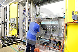 operator assembles machine in a factory - production of switch cabinets for industrial plant photo