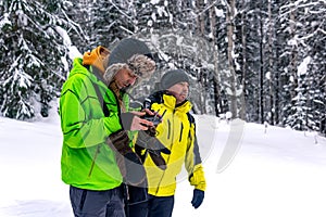 Operator with assistant controls a drone from a winter forest