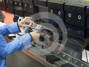 Operator bending metal sheet by sheet bending machine