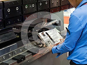 Operator bending metal sheet by sheet bending machine