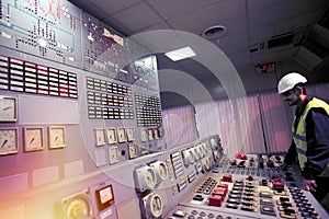 Operator holds hands on the control panel of old power plant