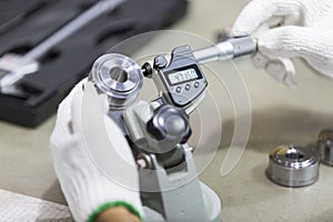 Operator inspection automotive part by micrometer