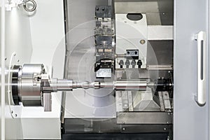 Operator machining automotive part by cnc turning machine.