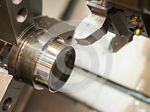 Operator machining mold and die part by CNC turning machine in f