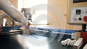 The operator of printing production pulls a printed sheet of paper