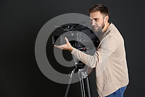 Operator with professional video camera on background