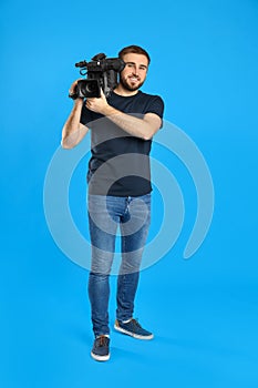 Operator with professional video camera on blue