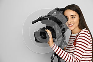 Operator with professional video camera on white background