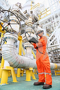 Operator recording operation of oil and gas process at oil and rig plant, offshore oil and gas industry, offshore oil and rig