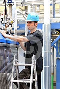 Operator repairs a machine in an industrial plant with tools