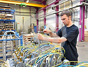 Operator repairs a machine in an industrial plant with tools - p