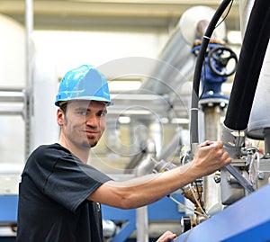 Operator repairs a machine in an industrial plant with tools - p photo