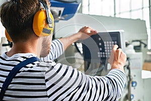 Operator Setting Up Machine Units at Factory