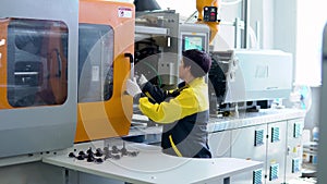 Operator takes out the plastic product from the forging apparatus