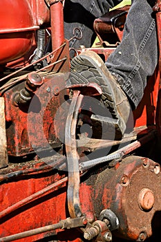 An operator of a tractor is holding the clutch in a depressed setting.