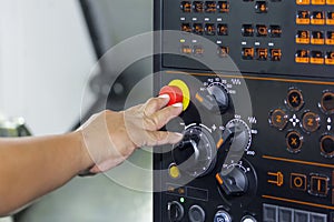 Operator use finger press emergency stop button of control panel cnc lathe machine