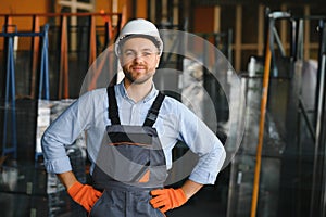 Operator wearing safety hat behind control panel on a factory