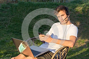 Operator works from home, in the garden, on a laptop with a helmet