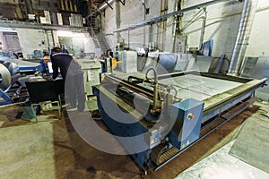 Operator works with plasma cutting machine with program control in metalwork factory